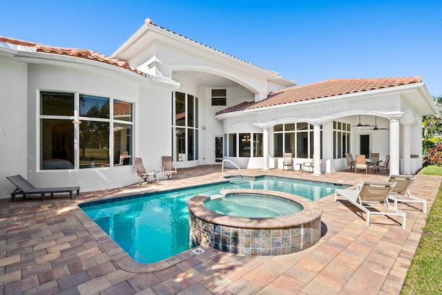 2885 Banyan Boulevard Cir NW, Boca Raton, FL 33431 - back of house featuring stucco siding, a tiled roof, a pool with connected hot tub, and a patio