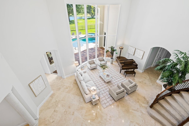 2885 Banyan Boulevard Cir NW, Boca Raton, FL 33431 - living room featuring arched walkways, stairway, a high ceiling, and baseboards
