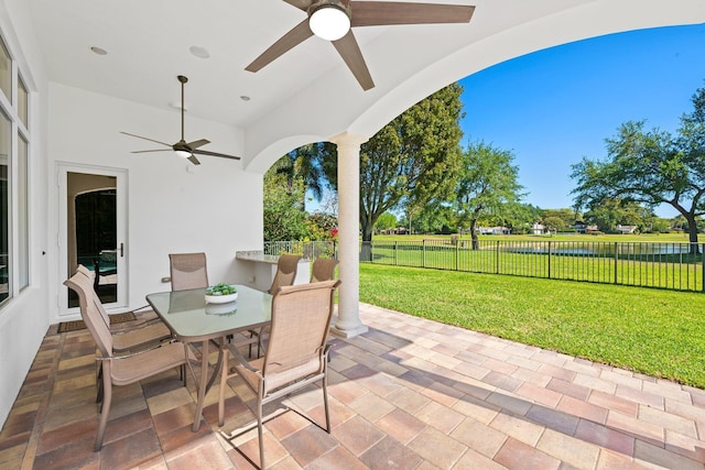 2885 Banyan Boulevard Cir NW, Boca Raton, FL 33431 - view of patio / terrace with fence, a water view, outdoor dining space, and ceiling fan