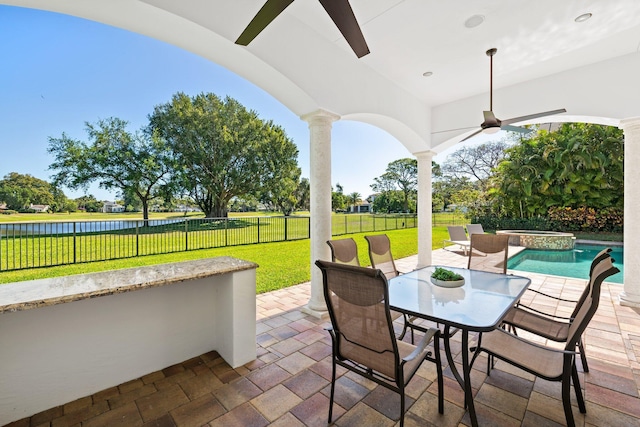 2885 Banyan Boulevard Cir NW, Boca Raton, FL 33431 - view of patio / terrace with a water view, a ceiling fan, outdoor dining space, a fenced backyard, and a pool with connected hot tub