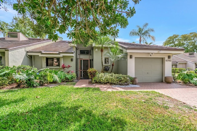 view of front of home featuring stucco siding, a tiled roof, and decorative driveway