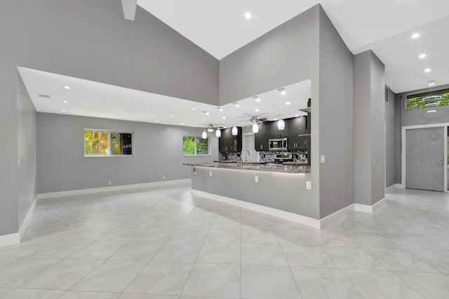 kitchen featuring baseboards, open floor plan, and stainless steel microwave