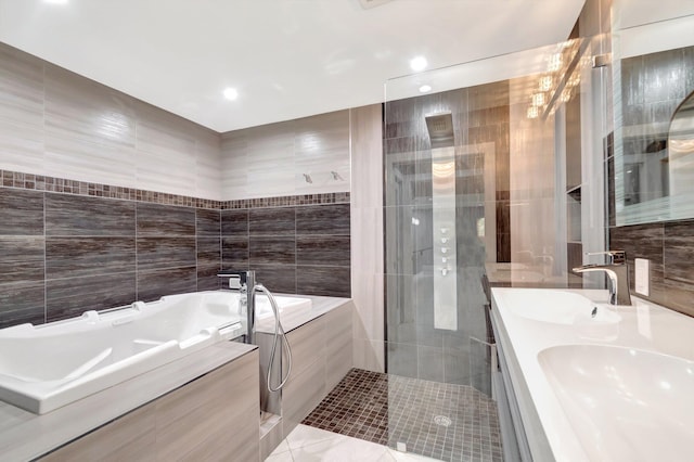 bathroom featuring tile walls, tiled shower, a sink, a bath, and double vanity