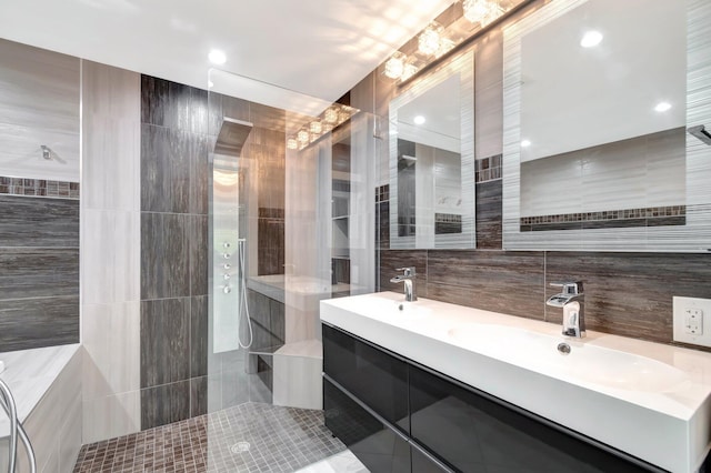 full bathroom with a sink, double vanity, tile walls, and a walk in shower