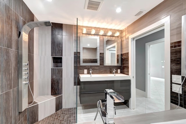 bathroom featuring tile walls, visible vents, tile patterned floors, and a walk in shower