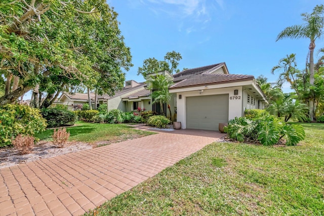 view of front of home featuring a front yard, decorative driveway, stucco siding, and an attached garage