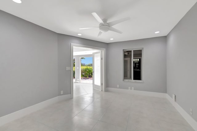 unfurnished room featuring baseboards, ceiling fan, and light tile patterned floors