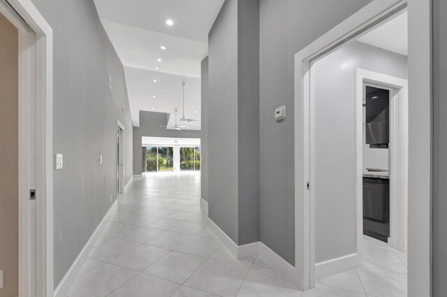corridor with light tile patterned flooring, baseboards, and recessed lighting