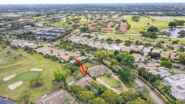 drone / aerial view featuring a water view, view of golf course, and a residential view