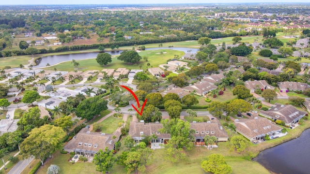 drone / aerial view with a residential view, golf course view, and a water view