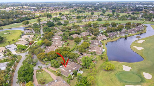 aerial view with golf course view, a water view, and a residential view