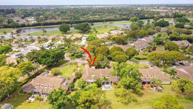 drone / aerial view featuring view of golf course, a residential view, and a water view