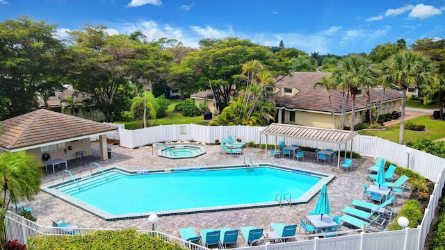 pool with a hot tub, a fenced backyard, and a patio