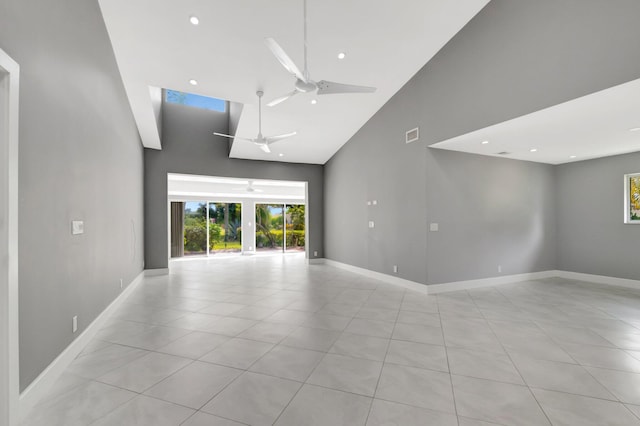 interior space featuring baseboards, ceiling fan, recessed lighting, and a towering ceiling