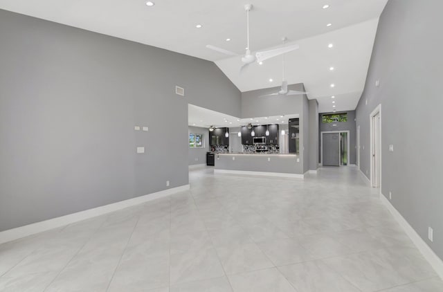 unfurnished living room featuring baseboards, ceiling fan, high vaulted ceiling, and recessed lighting