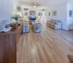 living room featuring light wood finished floors and ceiling fan