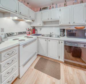 kitchen with white range with electric cooktop, light countertops, dishwasher, and light wood-type flooring