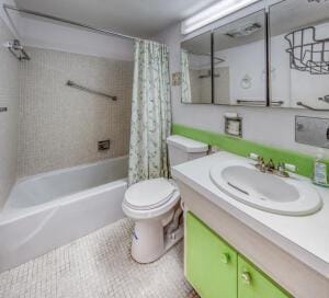 full bathroom featuring toilet, vanity, tile patterned floors, and shower / tub combo with curtain