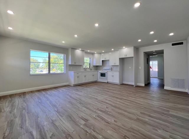 kitchen with visible vents, open floor plan, light countertops, and white range with electric cooktop