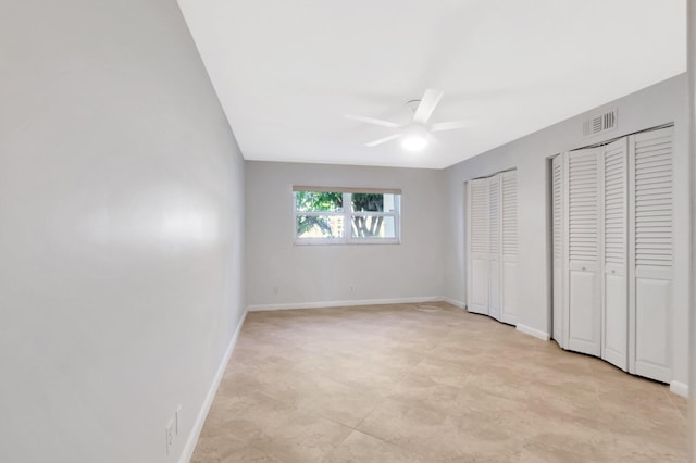 2601 NE 3rd Ct Unit 105, Boynton Beach, FL 33435 - unfurnished bedroom with multiple closets, baseboards, and ceiling fan