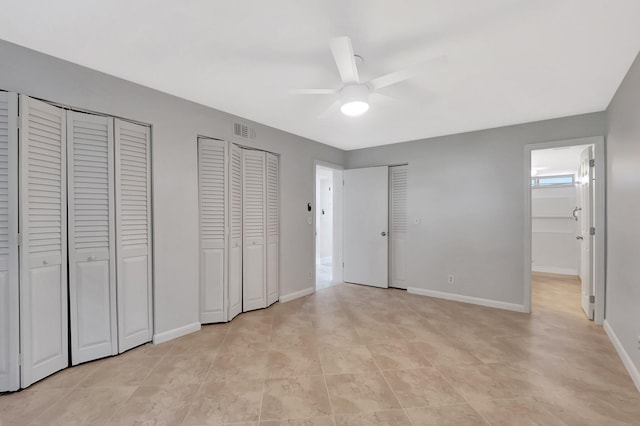 2601 NE 3rd Ct Unit 105, Boynton Beach, FL 33435 - unfurnished bedroom with multiple closets, baseboards, a ceiling fan, and light tile patterned floors