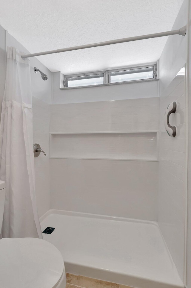 2601 NE 3rd Ct Unit 105, Boynton Beach, FL 33435 - bathroom with toilet, a stall shower, a textured ceiling, and tile patterned flooring
