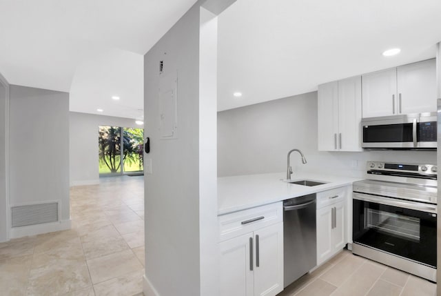 2601 NE 3rd Ct Unit 105, Boynton Beach, FL 33435 - kitchen with stainless steel appliances, a sink, light countertops, white cabinetry, and recessed lighting