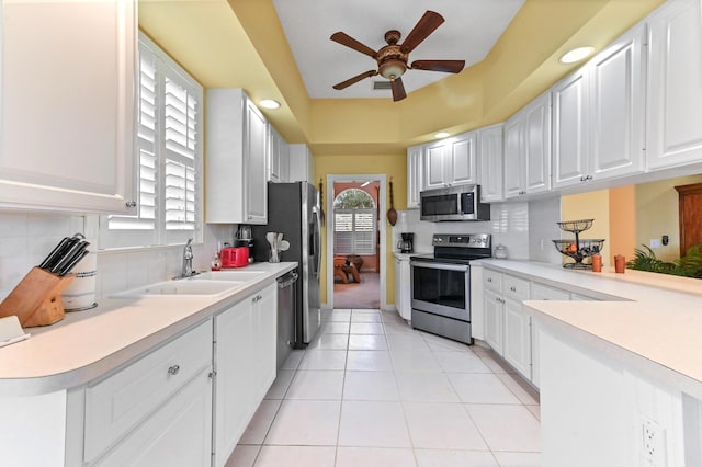 8378 Xanthus Ln, Wellington, FL 33414 - kitchen with stainless steel appliances, ceiling fan, decorative backsplash, white cabinetry, and recessed lighting