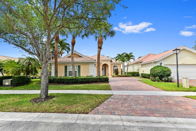 8378 Xanthus Ln, Wellington, FL 33414 - mediterranean / spanish home with stucco siding, decorative driveway, a front yard, and a tiled roof