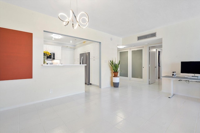 unfurnished living room featuring a raised ceiling, light tile patterned floors, baseboards, visible vents, and an inviting chandelier