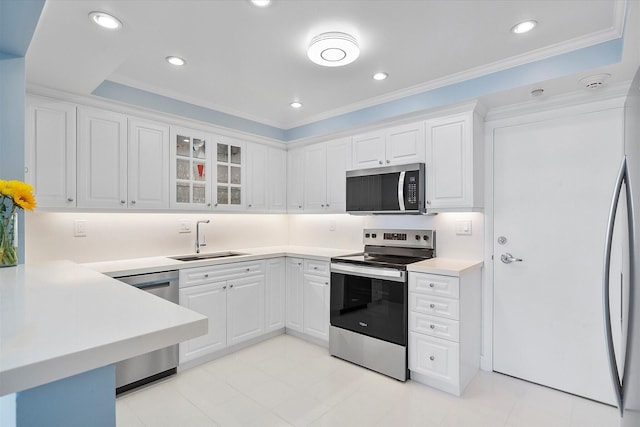 kitchen featuring white cabinets, light countertops, appliances with stainless steel finishes, glass insert cabinets, and a sink