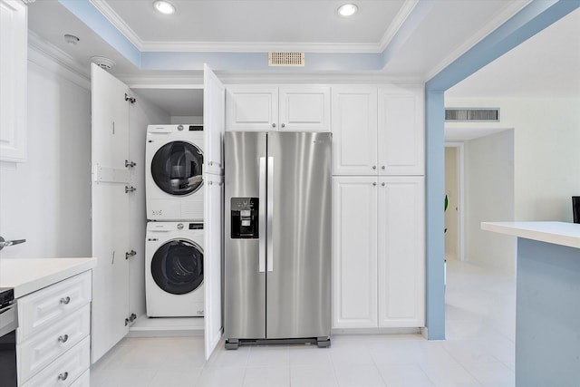 laundry area featuring visible vents, stacked washer / dryer, ornamental molding, and light tile patterned floors