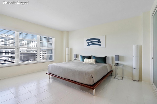 bedroom with baseboards and light tile patterned floors