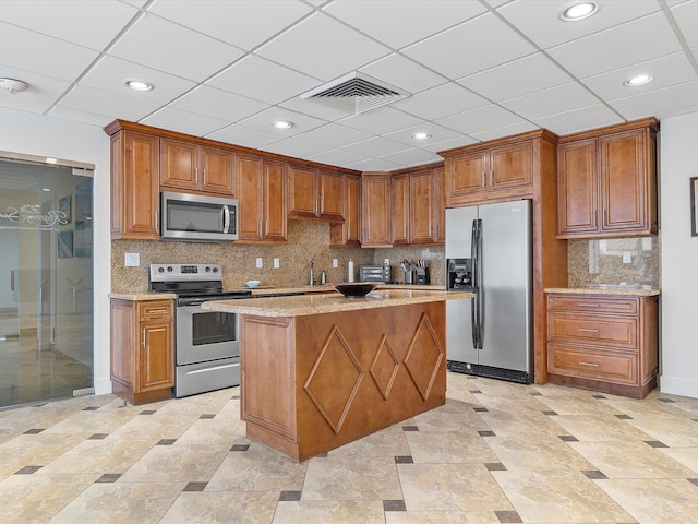 kitchen with stainless steel appliances, brown cabinets, and visible vents