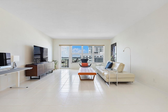 living area featuring baseboards and light tile patterned floors
