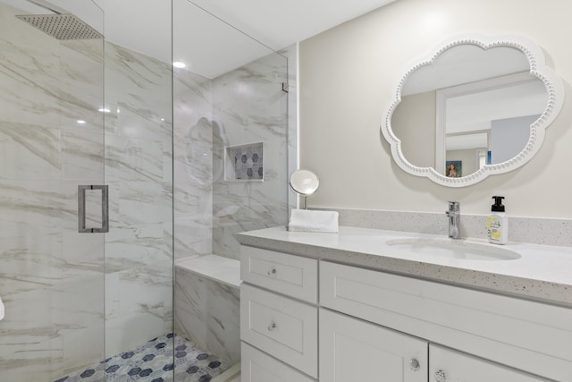 full bath with vanity and a marble finish shower
