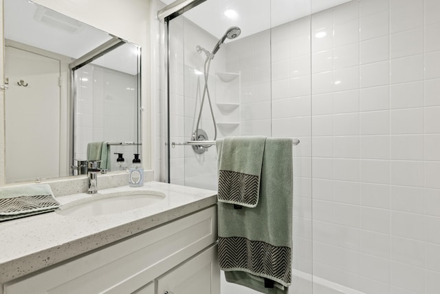 full bathroom featuring vanity and a tile shower