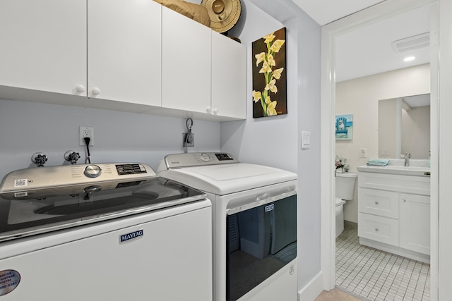 laundry room with separate washer and dryer, baseboards, light tile patterned floors, cabinet space, and a sink