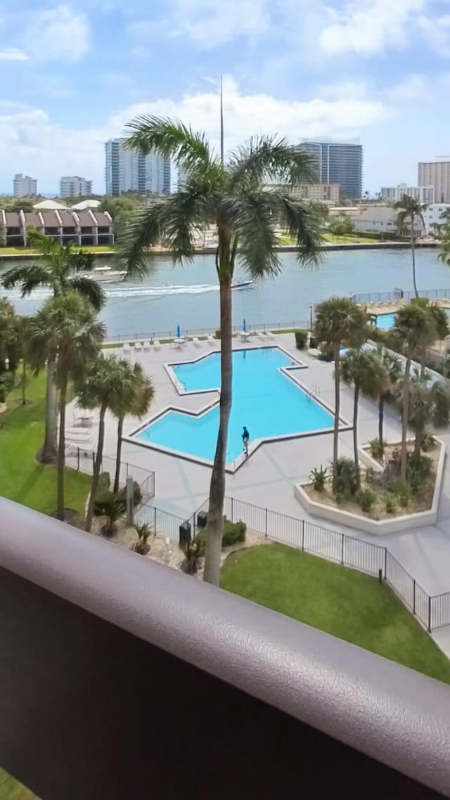 community pool with fence and a view of city