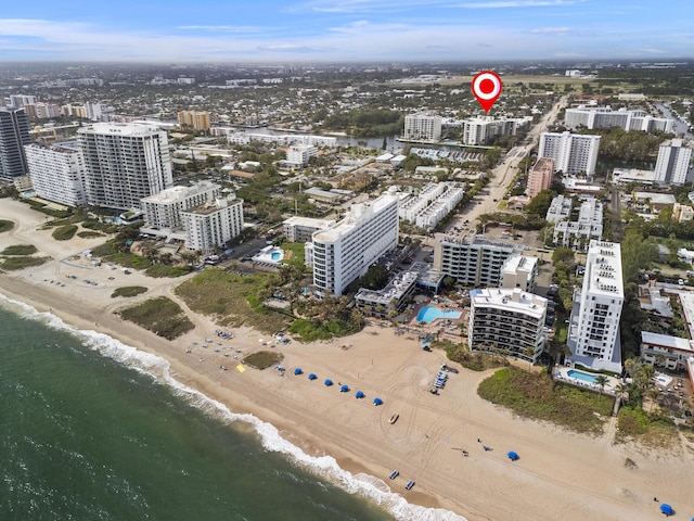 aerial view featuring a water view, a beach view, and a city view