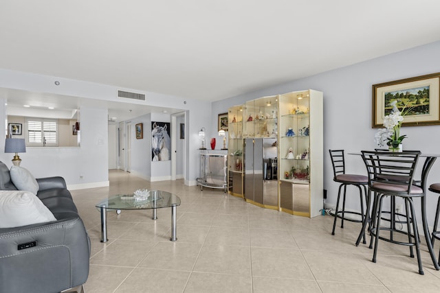 living room with visible vents, baseboards, and light tile patterned floors