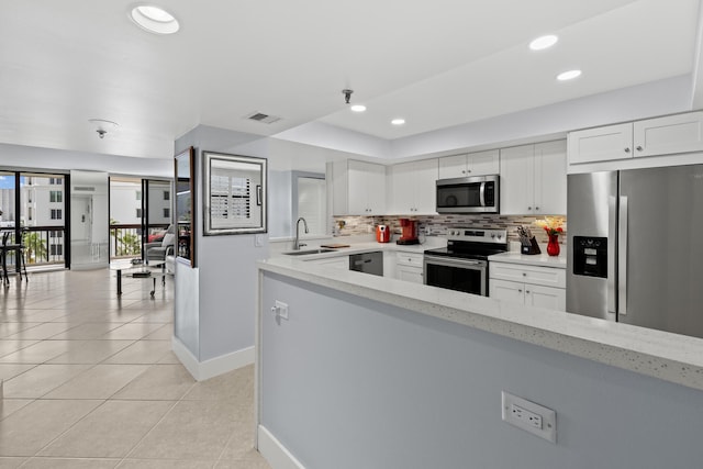 kitchen featuring visible vents, light tile patterned floors, a sink, stainless steel appliances, and backsplash