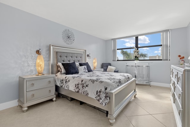 bedroom with light tile patterned floors and baseboards