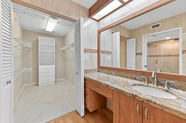 4734 Lucerne Lakes Blvd E Unit 302, Lake Worth, FL 33467 - full bath featuring double vanity, a walk in closet, a stall shower, and baseboards