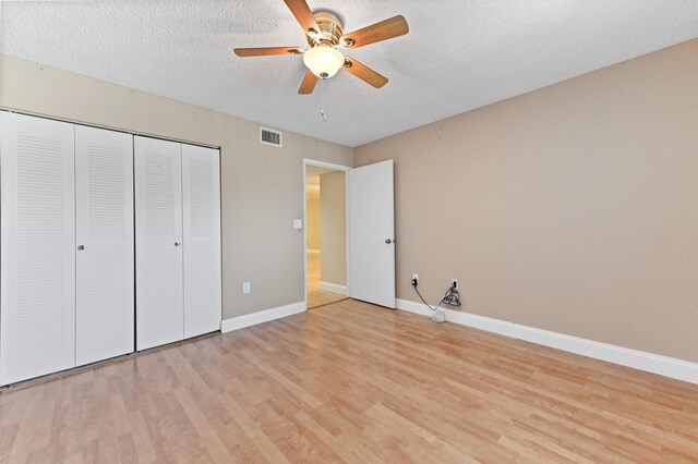 4734 Lucerne Lakes Blvd E Unit 302, Lake Worth, FL 33467 - unfurnished bedroom with light wood-type flooring, a textured ceiling, baseboards, a closet, and a ceiling fan