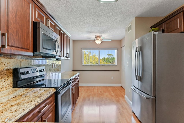 4734 Lucerne Lakes Blvd E Unit 302, Lake Worth, FL 33467 - kitchen featuring stainless steel appliances, light wood-type flooring, a ceiling fan, decorative backsplash, and baseboards
