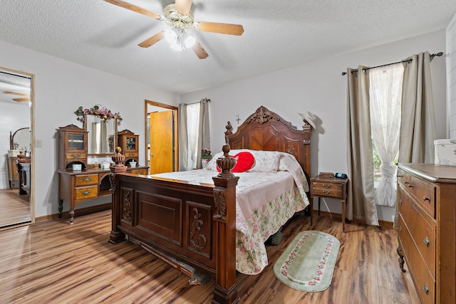 bedroom with a textured ceiling, light wood finished floors, and ceiling fan