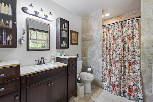 full bath featuring tile patterned floors, a tile shower, vanity, and toilet