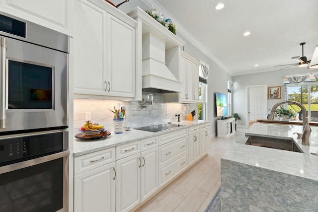 9129 SW Pepoli Way, Port Saint Lucie, FL 34987 - kitchen featuring a sink, black electric cooktop, custom range hood, double oven, and crown molding