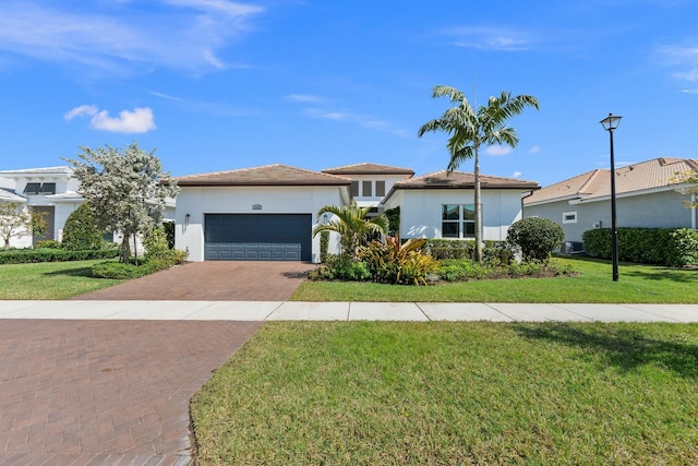 9129 SW Pepoli Way, Port Saint Lucie, FL 34987 - view of front facade with decorative driveway, an attached garage, stucco siding, and a front lawn